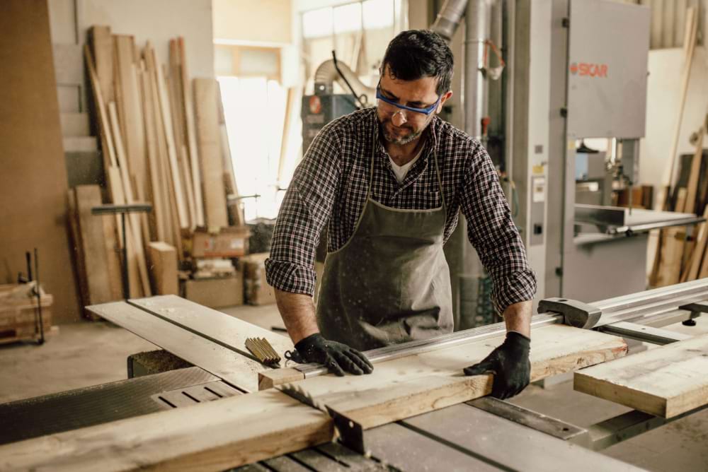 Carpenter working with circular saw at carpentry workshop